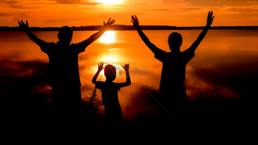 幸福的家庭站在黎明时刻自然的日落家庭轮廓图片