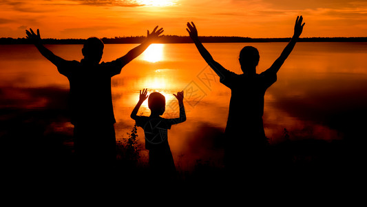 幸福的家庭站在黎明时刻自然的日落家庭轮廓图片