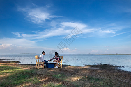 两个幸福的兄弟姐妹在大自然中的湖附近玩棋游戏图片