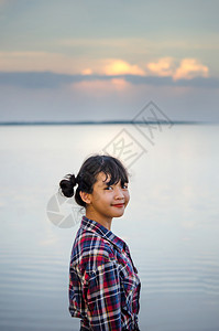 一位美丽的年轻亚洲女孩肖像她对着镜头微笑光亮的美丽年轻亚洲女孩图片