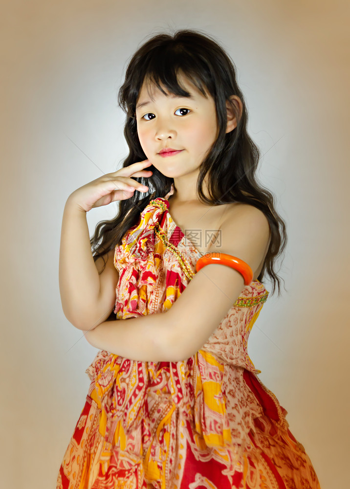 穿橙色裙子的亚洲小女孩肖像图片