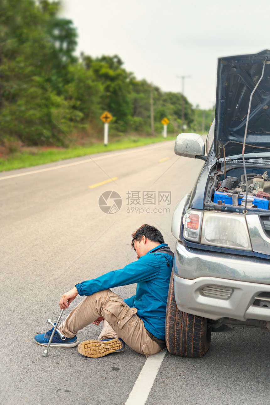 一个有压力的亚洲人他的车坏了他沮丧地看着引擎坏了一个亚洲人的破车出了问题图片