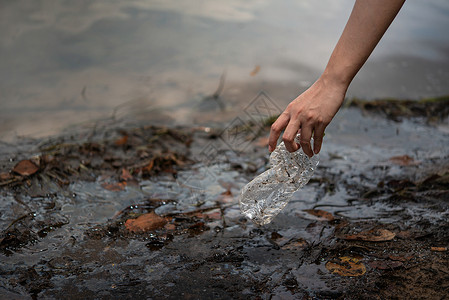 从水中取塑料瓶节省环境并克服塑料污染选择焦点手从水中取塑料瓶图片