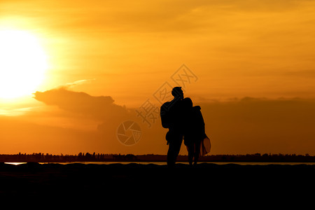 日落时在山上登的轮廓旅行者夫妇图片