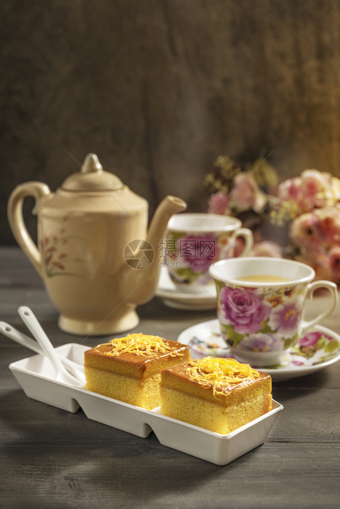 热茶和甜蛋糕放在木制桌边的热茶和甜蛋糕图片