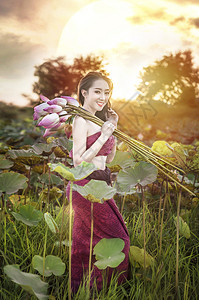 传统亚洲服装摘水百合花在园美丽的女图片