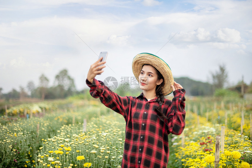 美丽的亚洲女在自然花朵田中的肖像快乐农民概念美丽的亚洲女持有花束朵美丽的亚洲女在自然田中的肖像快乐农民图片