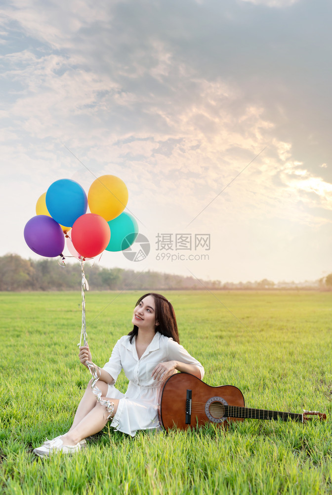 一个快乐的漂亮女人肖像气球在绿地放松快乐的漂亮女人气球图片