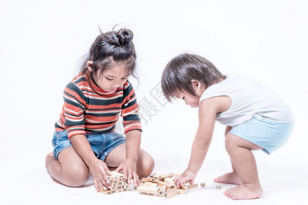 两个幸福的兄弟姐妹用木盒子玩游戏图片