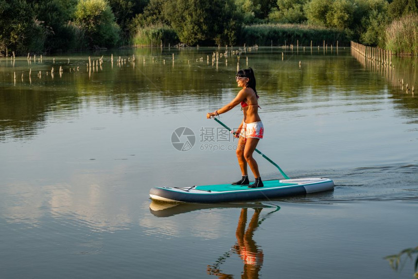 女子在湖上站着滑板年轻女孩在湖上渡水女游客在暑假时穿泳衣图片