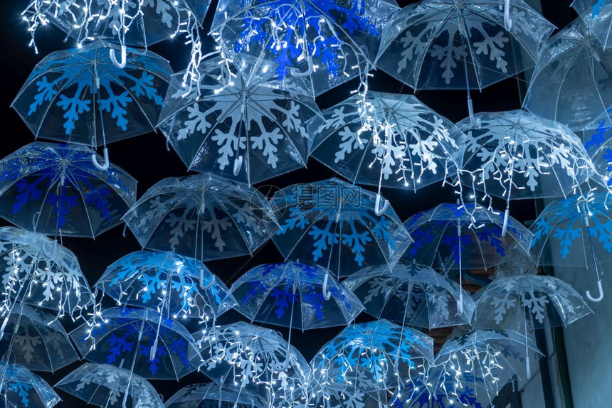 白色雨伞的美丽由圣诞灯照亮装饰着阿圭达葡萄牙街头图片