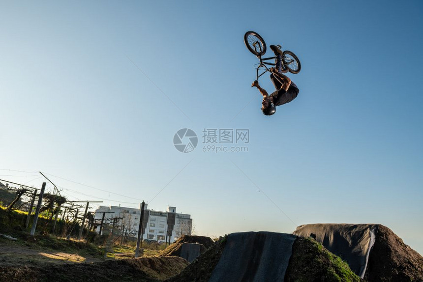 BMXBike回翻转跳在泥土轨道上图片