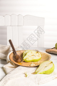 油腻的梨子有蜂蜜和坚果在木制桌上背景图片