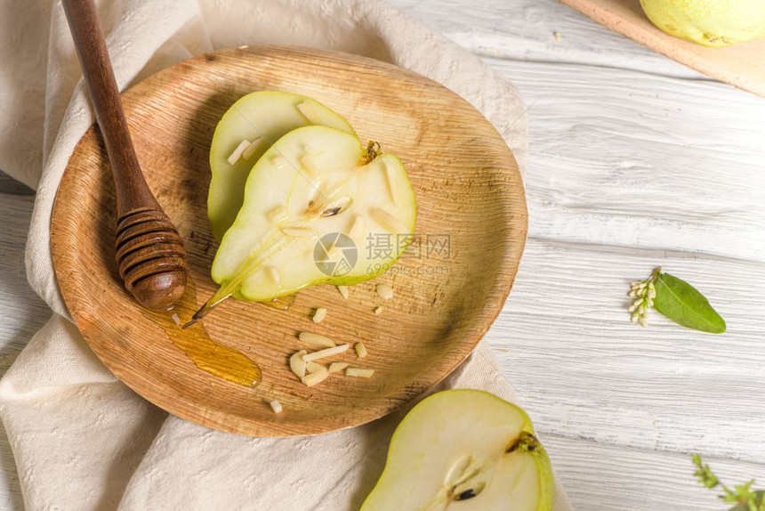 油腻的梨子有蜂蜜和坚果在木制桌上图片