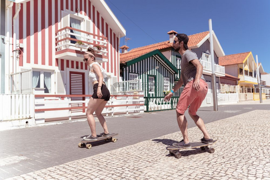 在葡萄牙阿维罗Aveiro典型的科斯塔新屋附近玩滑板的年轻活跃夫妇图片