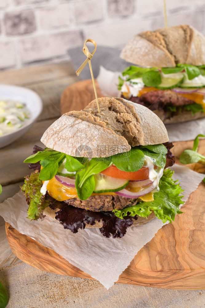 健康的素食汉堡新鲜蔬菜和酸奶酱在生锈的厨房柜台顶部图片