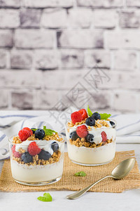 格拉诺黑莓和草土制酸奶以玻璃成浅白木本底健康食物概念图片