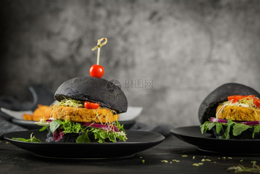 美味的烤肉汉堡和鸡豆蔬菜黑面包上的在木制柜台图片