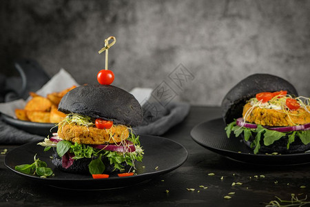 美味的烤肉汉堡和鸡豆蔬菜黑面包上的在木制柜台高清图片
