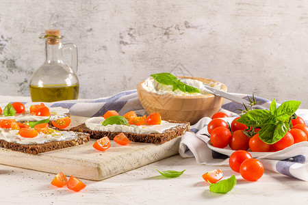 奶油酪橄榄和巴西尔酱樱桃红柿木板上新鲜的巴西尔叶高清图片