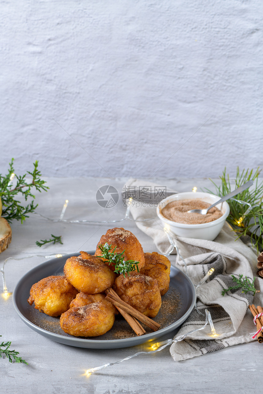 传统的葡萄牙圣诞甜点Sonhos糖和肉桂在厨房的柜台上图片