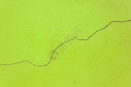 绿色旧墙中间的简单裂缝图片