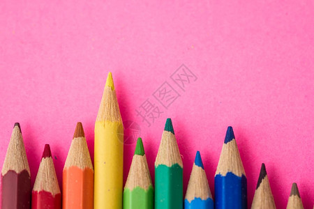 散布在粉红色背景的彩铅笔团背景图片