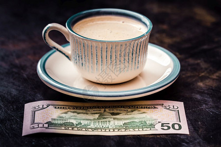 桌上咖啡杯旁边50美元钞票图片