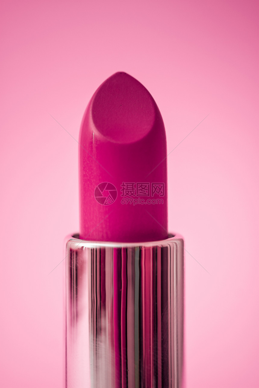 粉红色背景上的紫毛唇膏图片