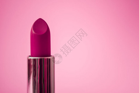 粉红色背景上的紫毛唇膏图片