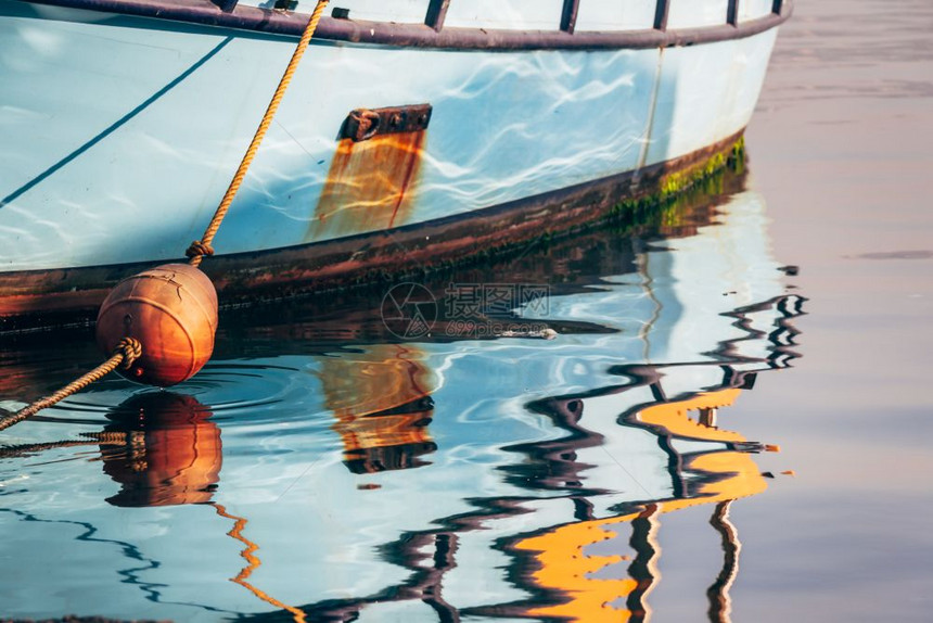 渔船在海岸水面上的多彩反射图片