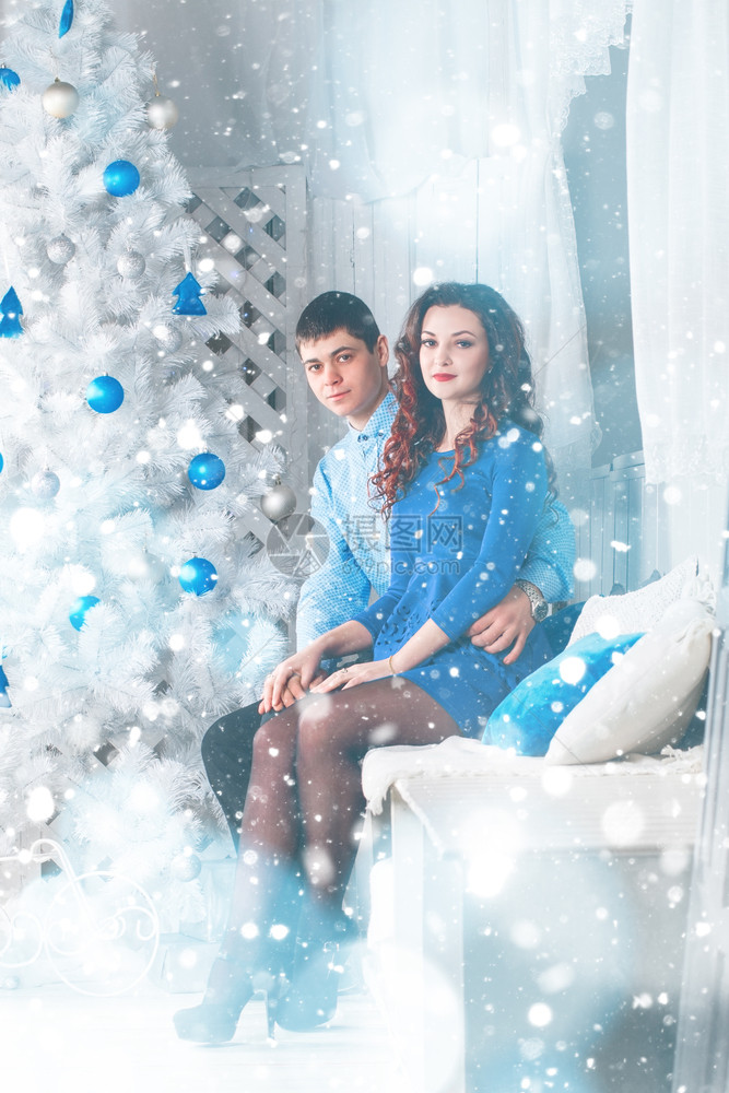 在蓝背景的圣诞节上相爱一对美丽情侣图片