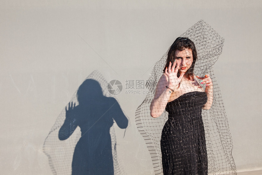 在混凝土结构背景上穿着未来服装的有吸引力女孩图片