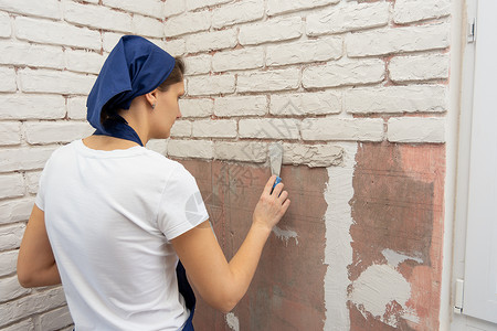 疲累的女孩在墙上仿制砖瓦的工作图片