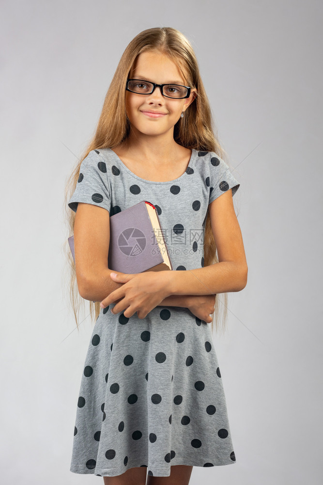 带着眼镜的女学生手里拿着一本书图片