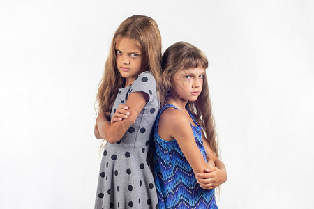 两个被冒犯的女孩彼此背对站在一起图片