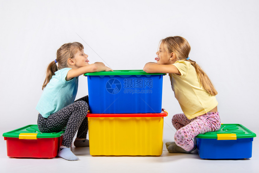 两个女孩坐在玩具的大盒子上互相用舌头说话图片