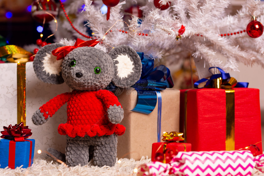 Plush老鼠和圣诞树下的礼物图片