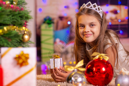 女孩躺在圣诞树上拿着小礼物图片