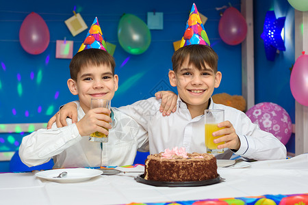 两个男孩在生日派对上吃蛋糕喝果汁图片