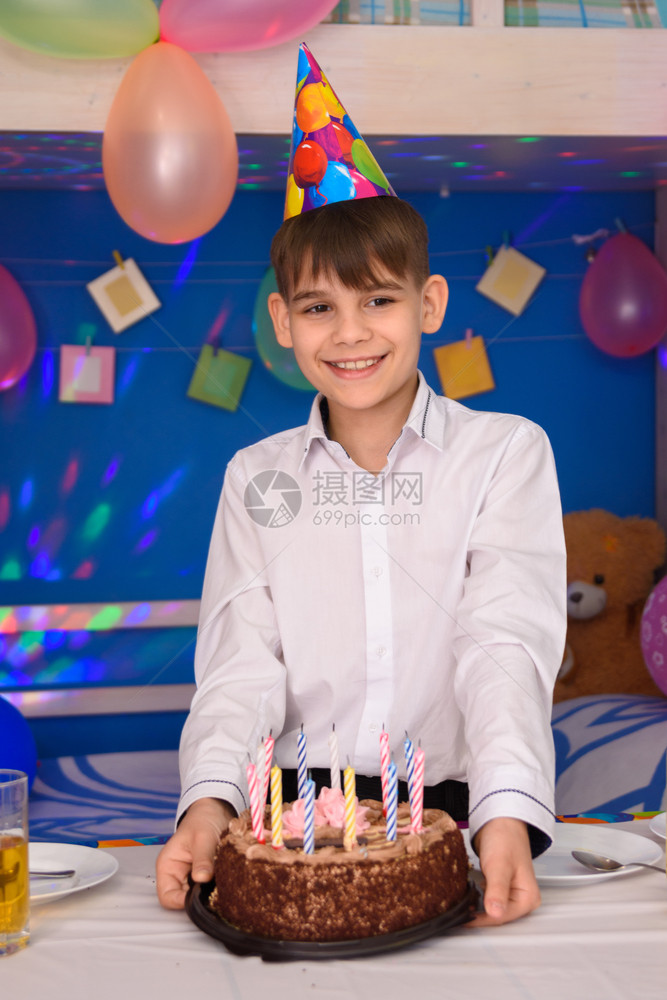 男孩拿着蛋糕站在桌子上图片