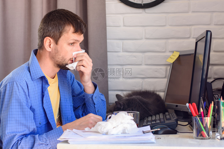 生病的自营职业者用餐巾擦鼻涕图片