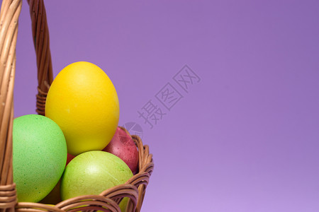 紫色背景的篮子里装满了彩色的蛋图片