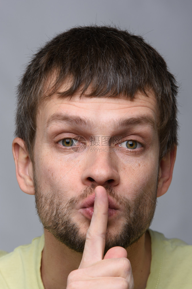 一个欧洲外貌的人肖像他用手指着嘴默的手势图片