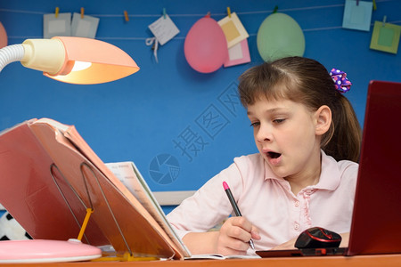 女孩坐在桌边长时间上课打哈打坐在桌子上图片
