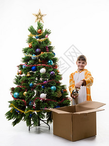 女孩从圣诞树上摘掉球然后放进盒子里图片