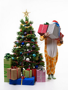 女孩拿着一堆礼物站在新年树边图片