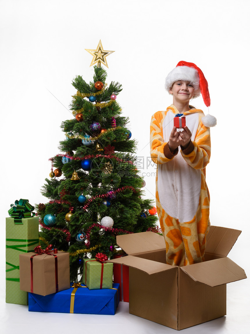 快乐的女孩手里拿着礼物站在盒子里储存圣诞玩具图片
