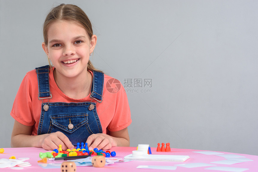坐在桌边玩棋盘游戏的女孩右手边自由空间图片