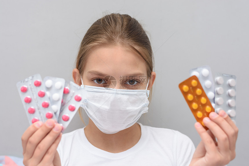 一名脸上戴医疗面具的女童用药瓶装水泡图片